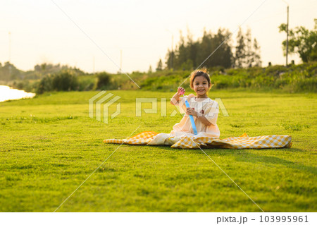 Happy little girl enjoying to play on green grass garden park 103995961