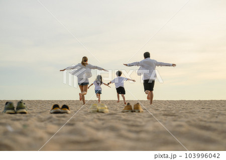 Happy family enjoying together on beach on holiday vacation Happy family enjoying together on beach on holiday vacation 103996042