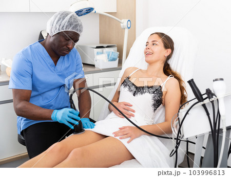 Cosmetologist reducing cellulite on the hips of a female patient Cosmetologist reducing cellulite on the hips of a female patient 103996813