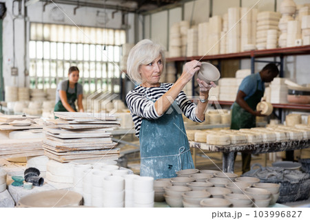 Senior woman potter with new crafted ceramic bowls Senior woman potter with new crafted ceramic bowls 103996827