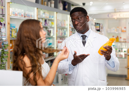 African american male pharmacist advises a girl a good hair care remedy African american male pharmacist advises a girl a good hair care remedy 103996985