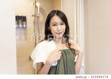 サウナの後シャワー室からシャワーを浴びて出てくる水着姿の若い女性 103999174