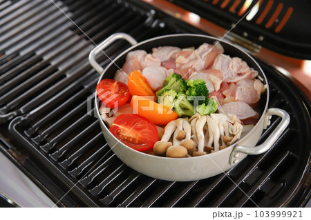 バーベキューコンロで肉と野菜の鍋を煮込むところ 103999921