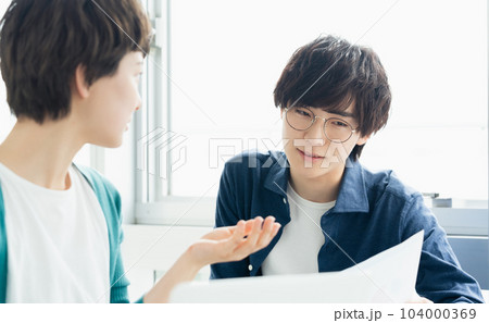 パソコンを見てミーティングをする若い男女 104000369