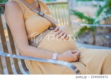 The young pregnant woman has a rest on a bench in park The young pregnant woman has a rest on a bench in park 104000872
