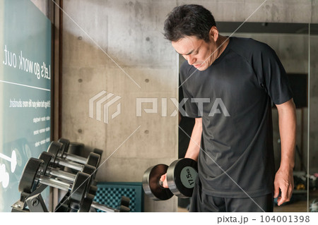 スポーツジムでダンベル・鉄アレイを使って腕を鍛える筋トレをするアジア人男性 104001398