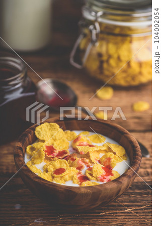 Breakfast with corn flakes, milk and berry syrup Breakfast with corn flakes, milk and berry syrup 104002054