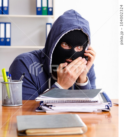 Male thief in balaclava in the office Male thief in balaclava in the office 104002324