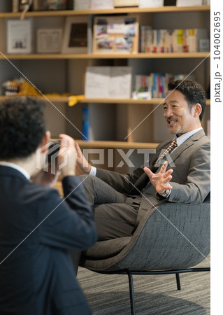 会社で社長への企業インタビューの取材の様子 カメラマンと社長 会社で社長への企業インタビューの取材の様子 カメラマンと社長 104002695