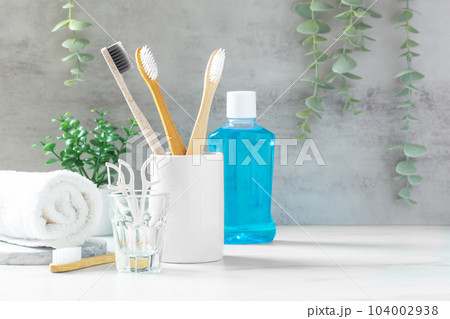 Toothbrush in cup with mouthwash and floss, oral and plant, dental care background Toothbrush in cup with mouthwash and floss, oral and plant, dental care background 104002938
