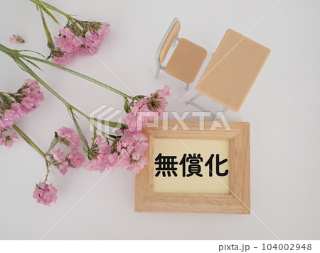無償化の文字と学校の机とイス、ピンクの花 無償化の文字と学校の机とイス、ピンクの花 104002948