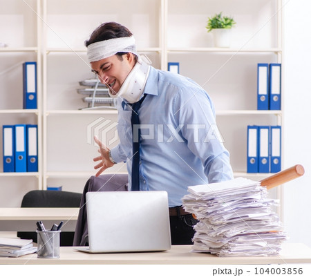 Young injured male employee working in the office 104003856