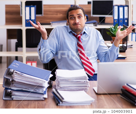Young male employee unhappy with excessive work 104003901