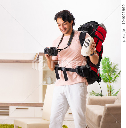 Young male tourist preparing for trip at home 104003960