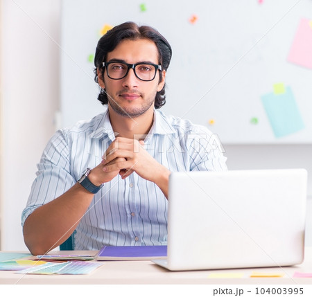 Young handsome male designer working in the office 104003995