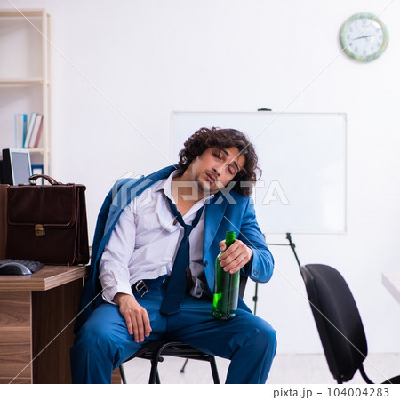 Young drunk employee in the office Young drunk employee in the office 104004283