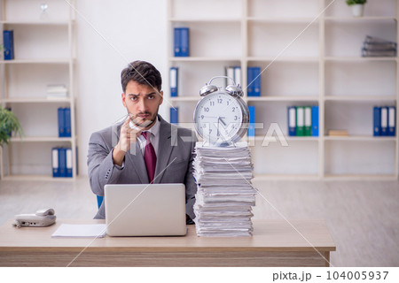 Young male employee in time management concept Young male employee in time management concept 104005937
