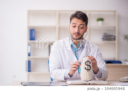 Young male doctor in remuneration concept 104005948