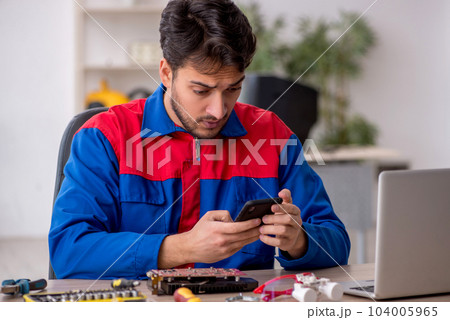 Young male repairman repairing computer 104005965