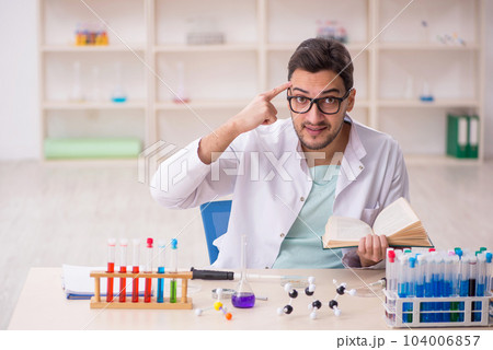Young male chemist sitting at the lab 104006857