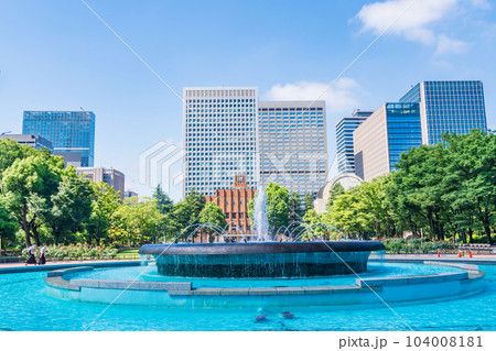 （東京）初夏の日比谷公園・涼し気な噴水と高層ビル群 104008181