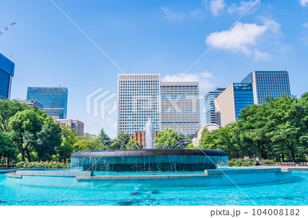 （東京）初夏の日比谷公園・涼し気な噴水と高層ビル群 104008182