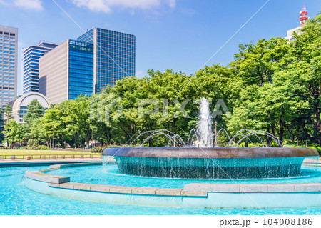 （東京）初夏の日比谷公園・涼し気な噴水と高層ビル群 104008186