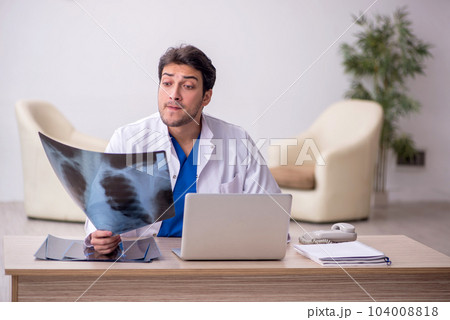 Young doctor radiologist sitting at the hospital 104008818