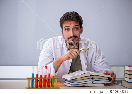 Young male chemist teacher in front of whiteboard 104008837