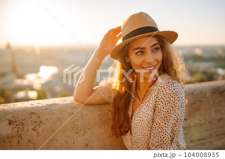 Portrait of happy tourist in hat at dawn enjoys cityscape. Traveling in Europe. Concept tourism. Portrait of happy tourist in hat at dawn enjoys cityscape. Traveling in Europe. Concept tourism. 104008935