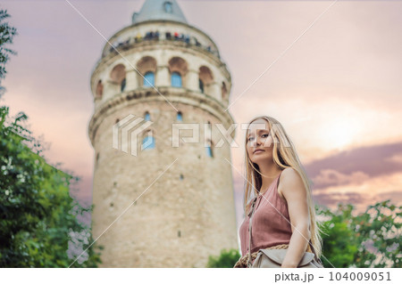 Portrait of beautiful woman tourist with view of Galata tower in Beyoglu, Istanbul, Turkey. Turkiye Portrait of beautiful woman tourist with view of Galata tower in Beyoglu, Istanbul, Turkey. Turkiye 104009051