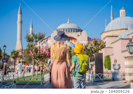 Mother and son Tourists enjoy beautiful view on Hagia Sophia Cathedral, famous islamic Landmark mosque, Travel to Istanbul, Turkey. Traveling with kids concept. Sunny day architecture and Hagia Sophia Mother and son Tourists enjoy beautiful view on Hagia Sophia Cathedral, famous islamic Landmark mosque, Travel to Istanbul, Turkey. Traveling with kids concept. Sunny day architecture and Hagia Sophia 104009126