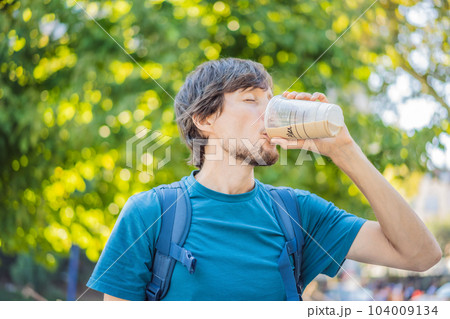 Man holding an iced coffee in a plastic to-go cup Man holding an iced coffee in a plastic to-go cup 104009134