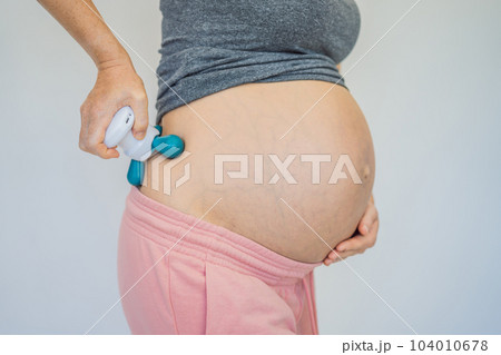 Self-massage with a massager for a pregnant woman Self-massage with a massager for a pregnant woman 104010678