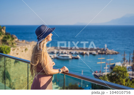 Woman tourist in Old town Kaleici in Antalya. Turkiye. Panoramic view of Antalya Old Town port, Taurus mountains and Mediterrranean Sea, Turkey 104010756