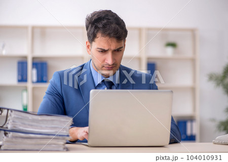 Young male employee working in the office Young male employee working in the office 104010931