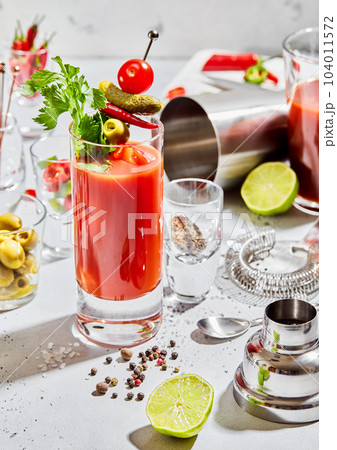 Preparation of bloody mary cocktail in bar with utensils and lime,pepper 104011572