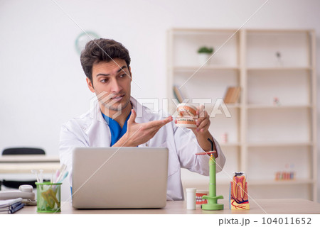 Young male dentist working in the clinic 104011652