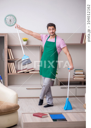 Young male contractor cleaning the house Young male contractor cleaning the house 104012162
