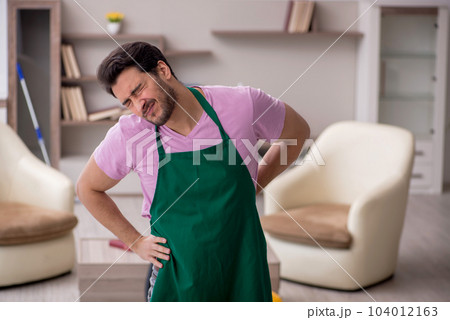 Young male contractor cleaning the house 104012163
