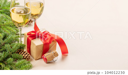 Xmas fir tree branch, Christmas gift box, champagne and space 104012230