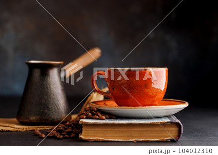 Rich coffee in a cup with aromatic roasted beans Rich coffee in a cup with aromatic roasted beans 104012310