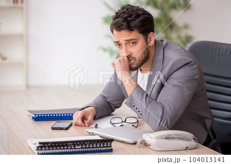 Young male employee working in the office Young male employee working in the office 104013141