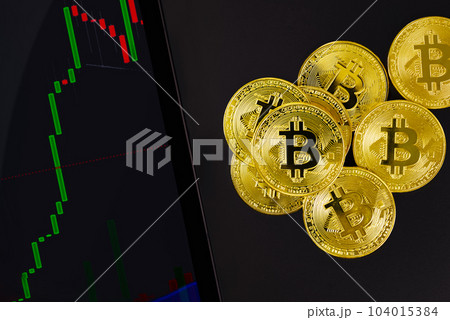 Bitcoin by digital tablet with bull exchange graph and crypto coins Bitcoin by digital tablet with bull exchange graph and crypto coins 104015384