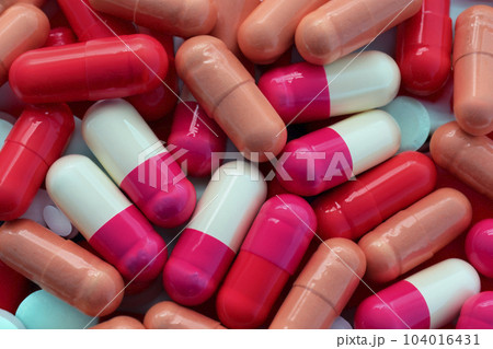 Pills. Set of pills. Bottle and scattered pills on color background, top view. Space for text. Heap of medical pills in white, blue and other colors. Pills in plastic package. 104016431