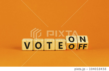 Vote on or off symbol. Businessman turns wooden cubes and changes word Vote off to Vote on. Beautiful orange table orange background. Business and vote on or off concept. Copy space. 104018438