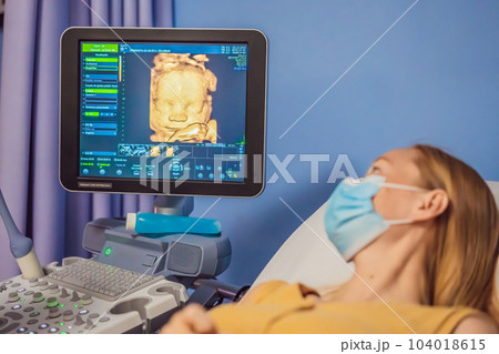 In the Hospital, Close-up Shot of the Doctor does Ultrasound Sonogram Procedure to a Pregnant Woman. Obstetrician Moving Transducer on the Belly of the Future Mother 104018615