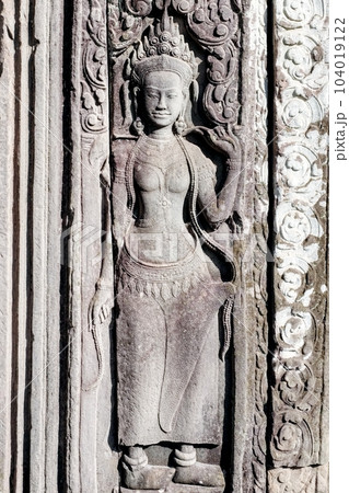 A sculptural image of a woman on the wall of an ancient temple in Cambodia, a stone bas-relief. 104019122