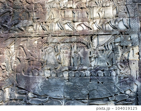 Ancient bas-reliefs illustrating historical and mythical subjects on the walls of the Khmer Bayon Temple. Ancient bas-reliefs illustrating historical and mythical subjects on the walls of the Khmer Bayon Temple. 104019125