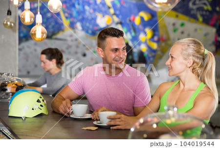 Climbers discussing over cup of coffee in sports bar at gym Climbers discussing over cup of coffee in sports bar at gym 104019544
